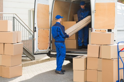 Removal team using safe lifting practices during a house move