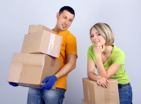 Professional movers handling packed boxes and furniture
